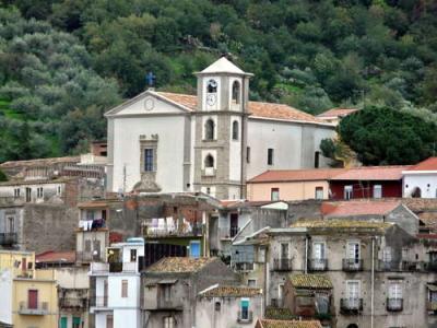 Paesaggio montano al tramonto con cime innevate e cielo arancione